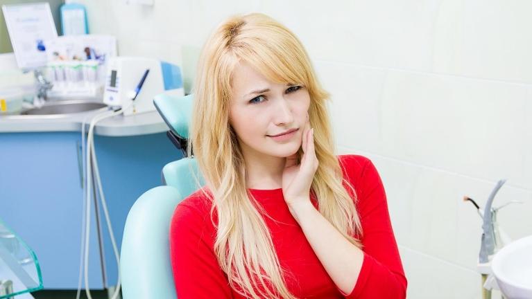 Patient with tooth pain in dental chair 