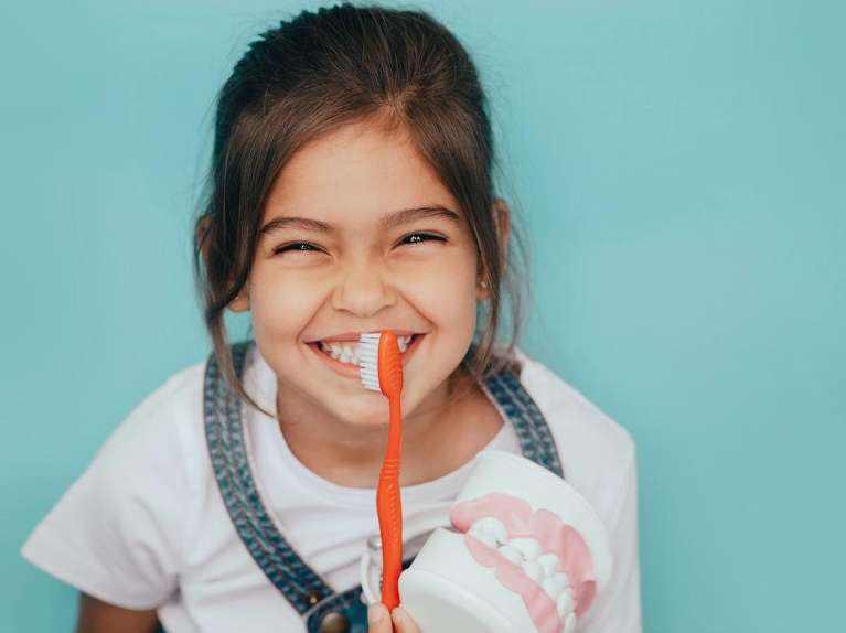 Child smiling with a toothbrush | Dentist in Brentwood
