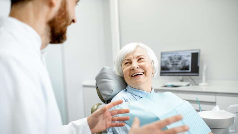 Dentist talking to elderly woman before getting dental implants, nashville tn