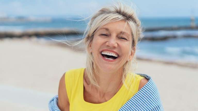 White woman smiling on a beach, nashville tn