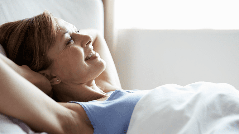 Woman smiling in bed | dental sedation tennessee